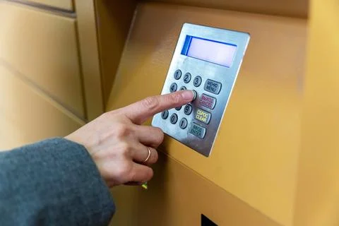 Woman's hand entering pin code on atm keypad for financial transaction Stock-Fotos