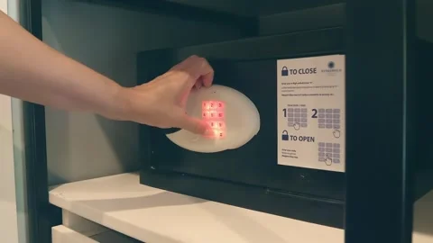 A woman's hand enters the code to open a compact safe, takes something out, Stock Footage 323959860