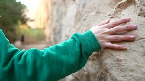Woman's hand feeling the stone of a cliff Stock Footage 262962745