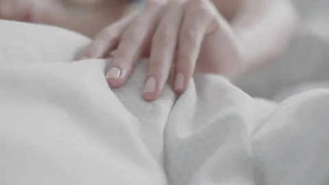 Woman's hand gently stroking the bed sheets Video stock 131064950