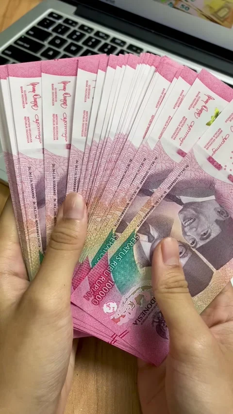 Woman's hand gesture counting red hundred thousand rupiah banknotes Video stock 295987161