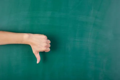 Woman's hand gesturing thumbs down against chalkboard Stock Photos