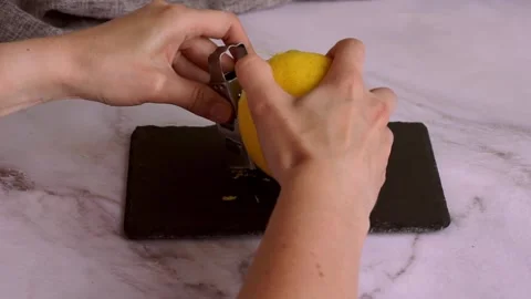 Woman's hand grates a lemon on a grater to get the zest. Stock Footage 204740023