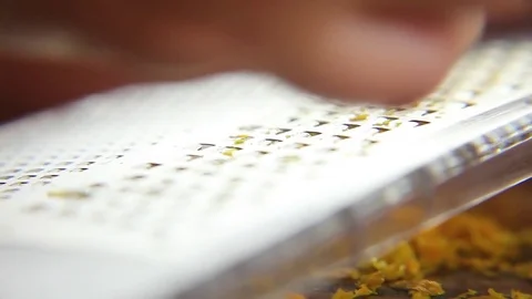 Woman's hand grating orange peel with grater Stock-Footage 76099466