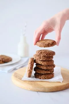 Woman's hand holding a cookie from a stack freshly baked Stock Photos