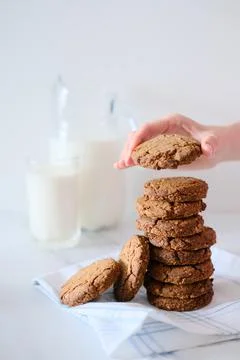 Woman's hand holding a cookie from a stack freshly baked Foto stock