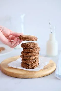 Woman's hand holding a cookie from a stack freshly baked Stock Photos