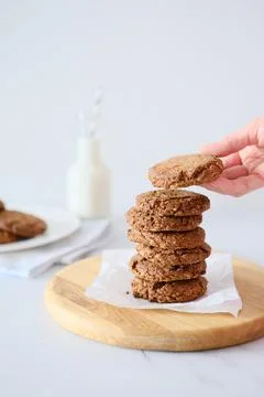 Woman's hand holding a cookie from a stack freshly baked Stock Photos
