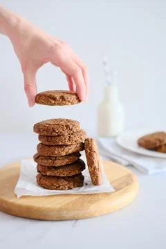 Woman's hand holding a cookie from a stack freshly baked Stock Photos