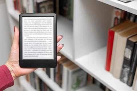 A woman's hand holding an e-book. Stock Photos