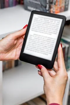 A woman's hand holding an e-book, vertical photo. 스톡 사진