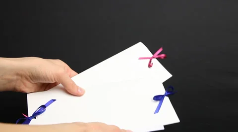 Woman’s hand holding holiday envelope, black background Stock Footage 33394664