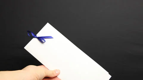 Woman’s hand holding holiday envelope, black background Stock Footage 33397612