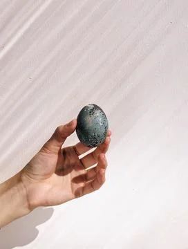 Woman's hand holding a painted Easter egg Stock Photos