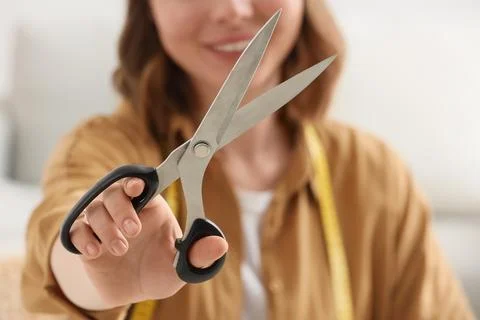 Womans hand holding sharp tailor scissors with open blades, crafting and sewi Stock Photos