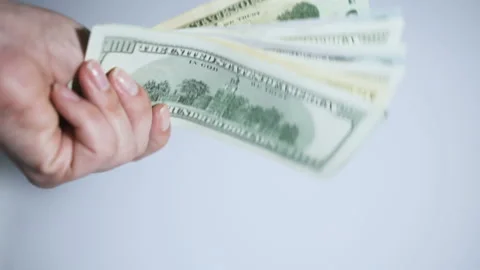 A woman's hand holding the US dollars on white background. Close-up Stock Footage 104938403