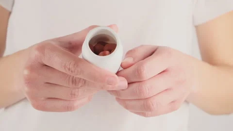 A woman's hand holds a bottle with tablets that are needed for the treatment ove Stock Footage 277498537