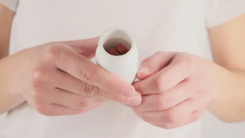 A woman's hand holds a bottle with tablets that are needed for the treatment ove Stock Footage 279070005