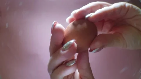 A woman's hand holds an egg and breaks it with a knife, a view of the broken egg 스톡 동영상 145707779