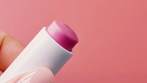 Womans hand holds lipstick on colored background. Stock Footage 249110232