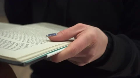 A woman's hand holds an open book Stock Footage 168653687