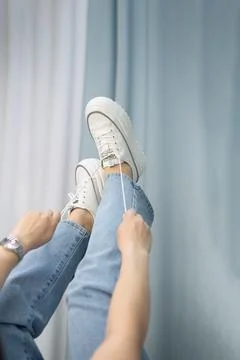 A woman's hand holds a pair of comfortable shoes in her hands. sneakers. woman Stock Photos