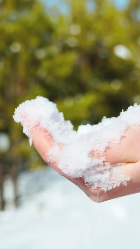 A woman's hand holds the pure and crumbly white snow. Video stock 345014580