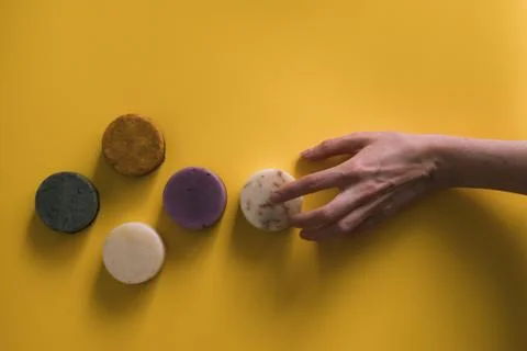 A woman's hand holds a solid bar of shampoo or soap. Stock Photos