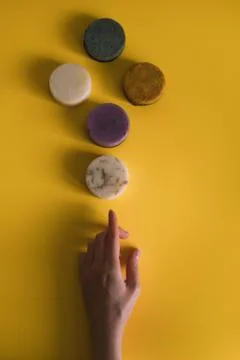 A woman's hand holds a solid bar of shampoo or soap. Stock Photos