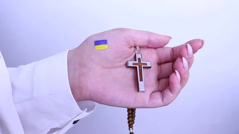 Woman's hand with the image of the flag of ukraine holds a cross, stop the war Stock Footage 202070626
