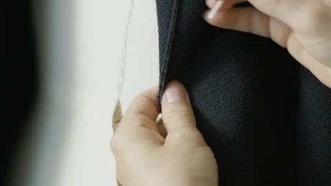 Woman's hand inserting needle in black fabric Stock Footage 124244181