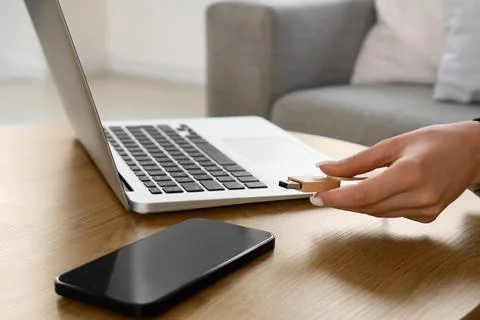 Womans hand inserting wooden USB flash drive into laptop computer for data tr Foto stock