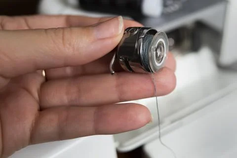 A woman's hand inserts a shuttle into a sewing machine 写真素材