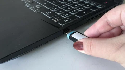 A womans hand inserts a USB flash drive into the laptop connector close-up. Data Stock Footage 320523720