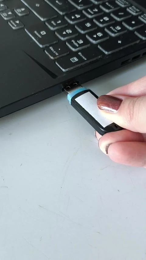 A womans hand inserts a USB flash drive into the laptop connector close-up. Data Stock Footage 320523760