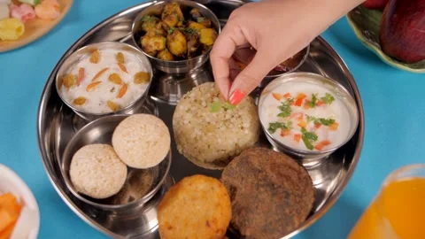Woman's hand keeping mint leaves on the freshly cooked Sabudana Khichdi Stock Footage 154848205