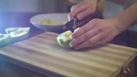 Woman's hand with a knife cuts the apples on the wooden board in the kitchen Stock Footage 70703921