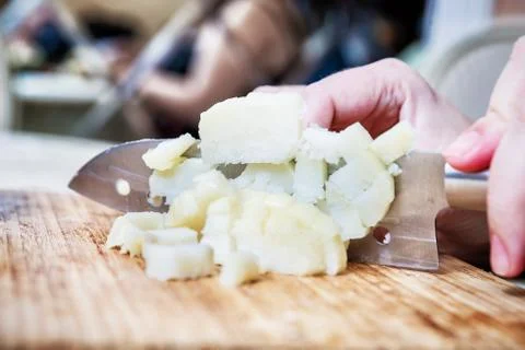 Woman's hand with a knife cutting the boiling potatoes Stock Photos