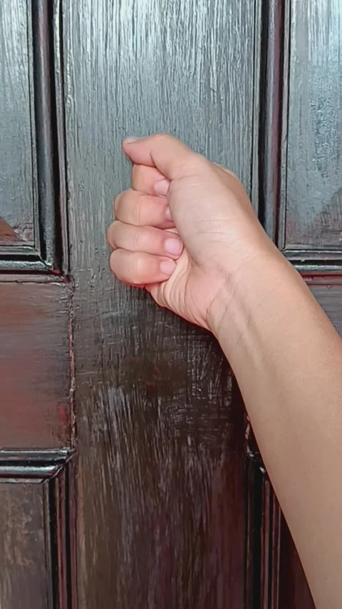 Woman's hand knocking with back of fist on wooden door. Video stock 291095601