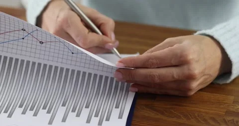Womans hand leafing through documents with charts and signing with pen in office Video stock 144319597