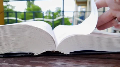 Woman's hand leisurely flips through book. Stock Footage 246943605