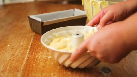 Woman's hand leveling the cake batter on baking container Stock-Footage 76099681