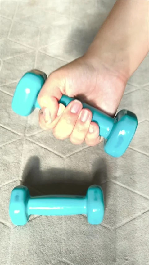 A womans hand lifts a small dumbbell. Stock Footage 313107053