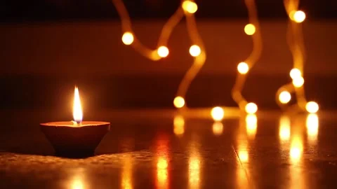Woman's hand lighting decorative Diyas, Lighting diya, Diwali creative Stock Footage 143025603