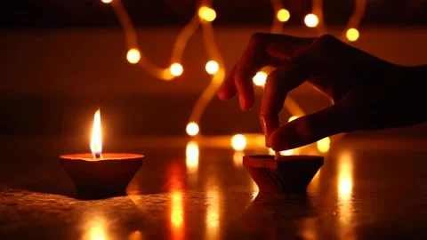 Woman's hand lighting decorative Diyas, Lighting Diya and walking, Happy Diwa Stock Footage 143025858