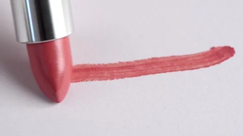 A woman's hand with lipstick making a mark on a white background. Cosmetic lip g Stock Footage 247089226