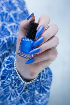 Woman's hand with long nails and bright blue manicure Stockfoto's