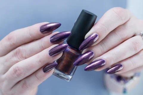 Woman's hand with long nails and multicolored nail polish, blue and brown 스톡 사진