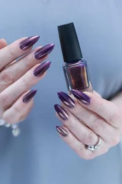 Woman's hand with long nails and multicolored nail polish, blue and brown Stockfoto's
