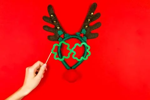 Woman's hand making flat designed funny decorating santa's christmas deer wit Stock Photos